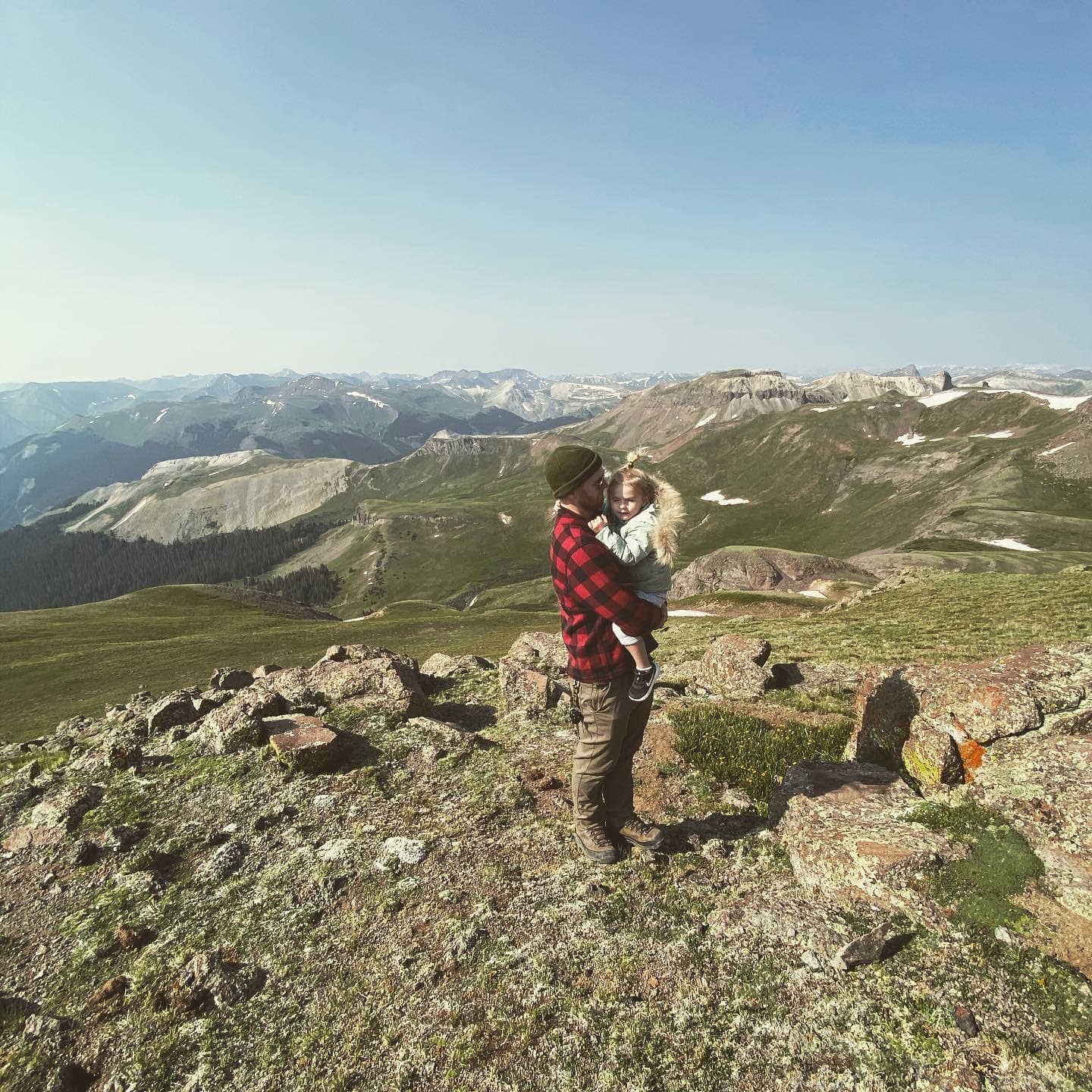 Austin Nicholas holding his daughter Surrey on a mountain ridge in Colorado